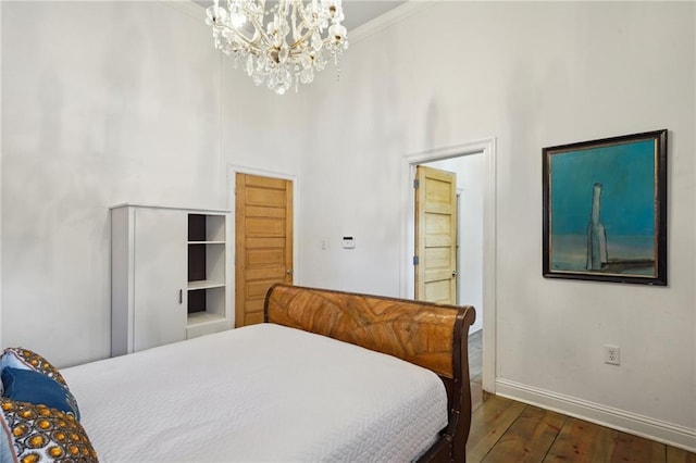 bedroom featuring a high ceiling, crown molding, an inviting chandelier, and dark hardwood / wood-style flooring