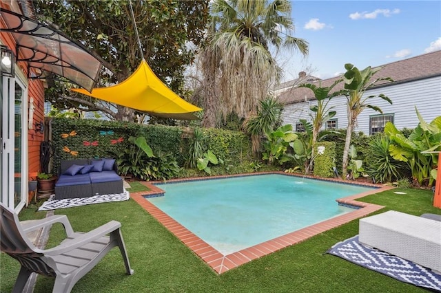 view of pool featuring pool water feature, an outdoor living space, and a yard