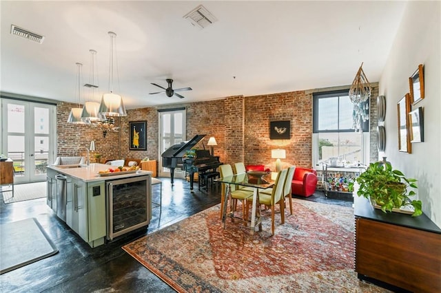 kitchen with beverage cooler, a kitchen island with sink, a wealth of natural light, and hanging light fixtures