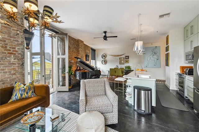 interior space with sink, french doors, ceiling fan with notable chandelier, and brick wall