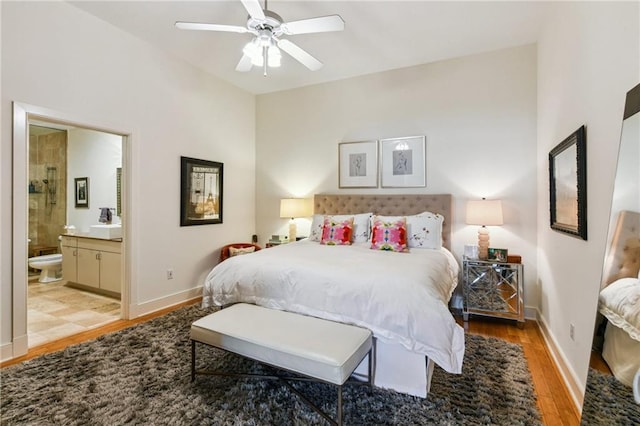 bedroom featuring light wood-type flooring, ceiling fan, and connected bathroom