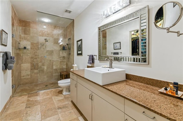 bathroom with walk in shower, vanity, and toilet