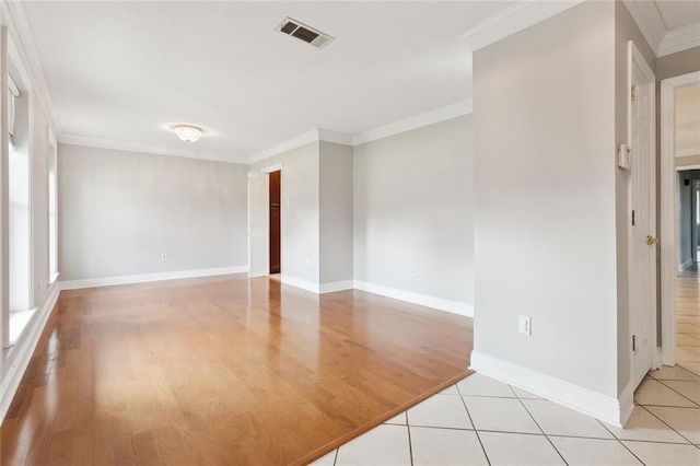 empty room with light tile patterned floors and crown molding