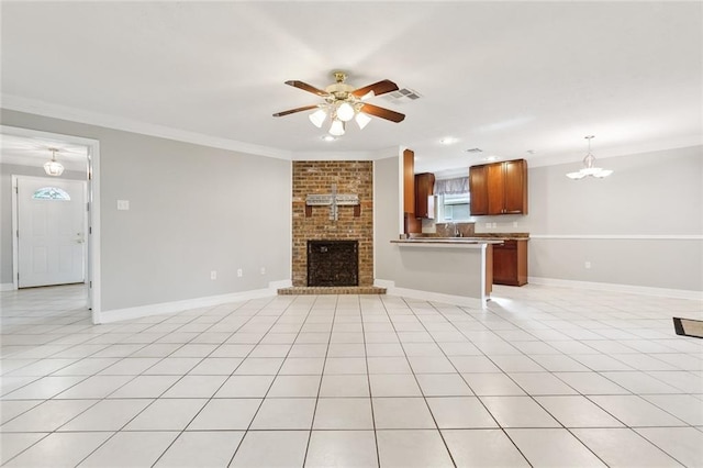 unfurnished living room with ceiling fan with notable chandelier, light tile patterned flooring, a fireplace, and crown molding