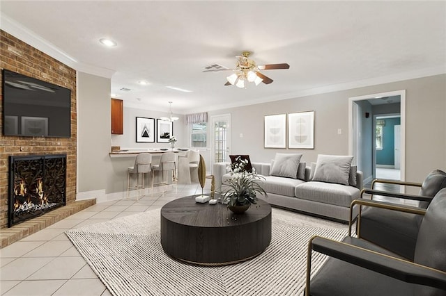 tiled living room featuring ornamental molding, ceiling fan, and a brick fireplace