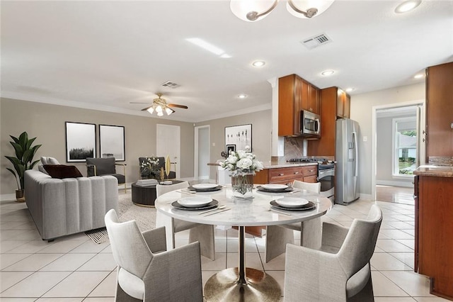 dining space featuring ceiling fan, light tile patterned floors, and crown molding