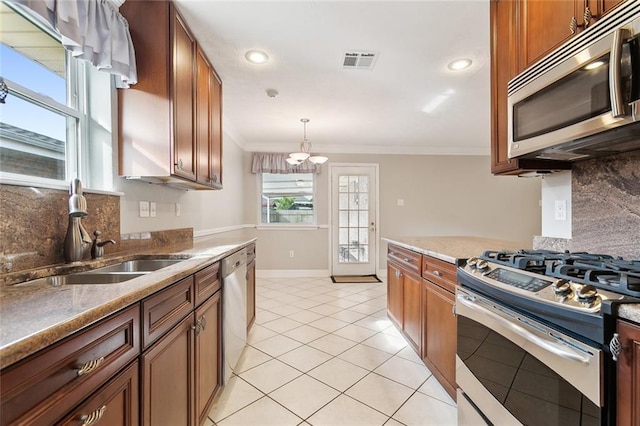 kitchen with appliances with stainless steel finishes, ornamental molding, sink, an inviting chandelier, and decorative light fixtures