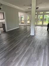 unfurnished living room with ornamental molding and dark hardwood / wood-style floors