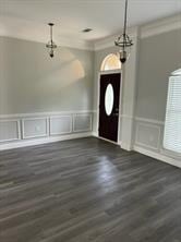 foyer featuring ornamental molding and dark wood-type flooring