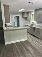 kitchen featuring kitchen peninsula, hardwood / wood-style floors, gray cabinets, and dishwasher