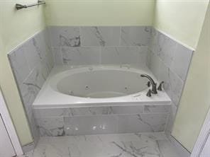 bathroom with tiled tub