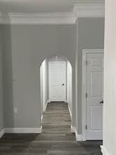 hallway with ornamental molding and dark hardwood / wood-style floors