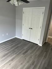 unfurnished bedroom featuring ceiling fan, a closet, and dark hardwood / wood-style floors