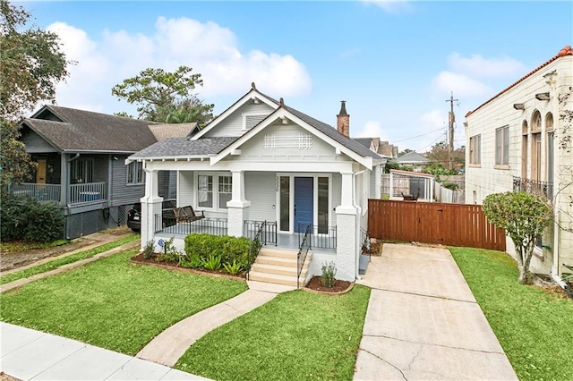 view of front of home with covered porch and a front yard