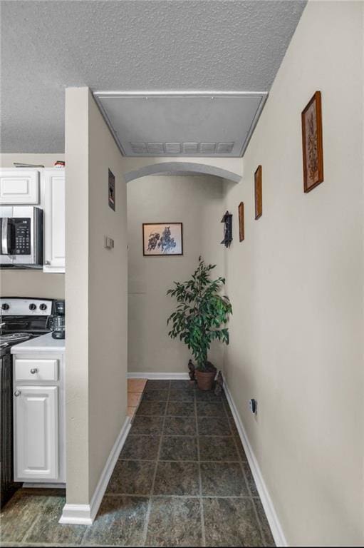 hall featuring a textured ceiling