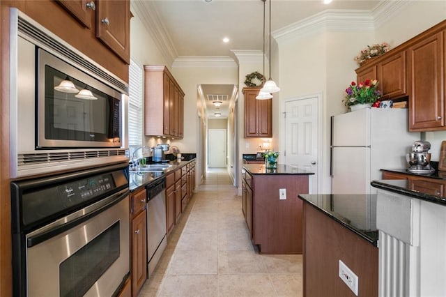 kitchen with dark stone countertops, appliances with stainless steel finishes, a center island, light tile patterned floors, and sink