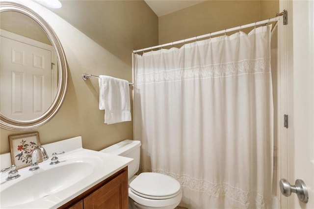 bathroom featuring a shower with shower curtain, vanity, and toilet