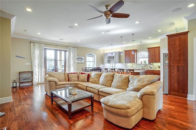 living room featuring ceiling fan, crown molding, and dark hardwood / wood-style flooring