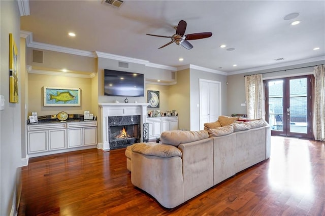 living room with french doors, ceiling fan, a premium fireplace, dark hardwood / wood-style floors, and crown molding