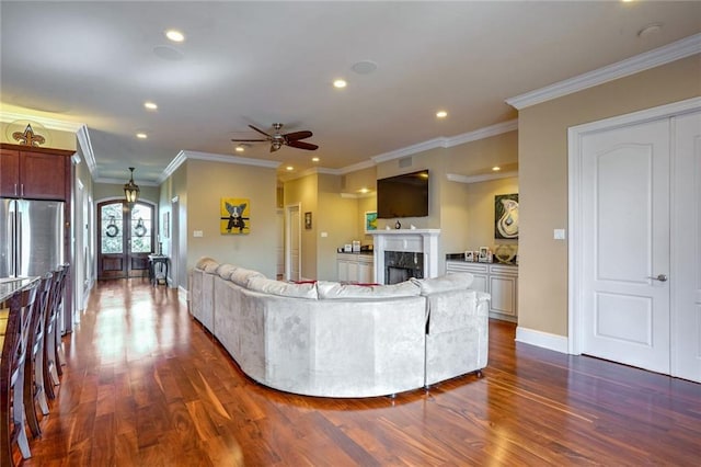 living room with french doors, ceiling fan, ornamental molding, a premium fireplace, and dark wood-type flooring