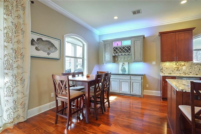 dining space featuring dark hardwood / wood-style flooring and crown molding