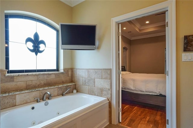 bathroom featuring a bathtub, hardwood / wood-style flooring, crown molding, and a wealth of natural light