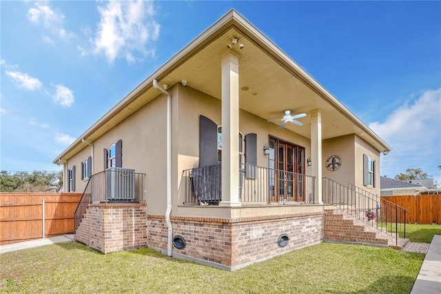 view of home's exterior with a yard and ceiling fan