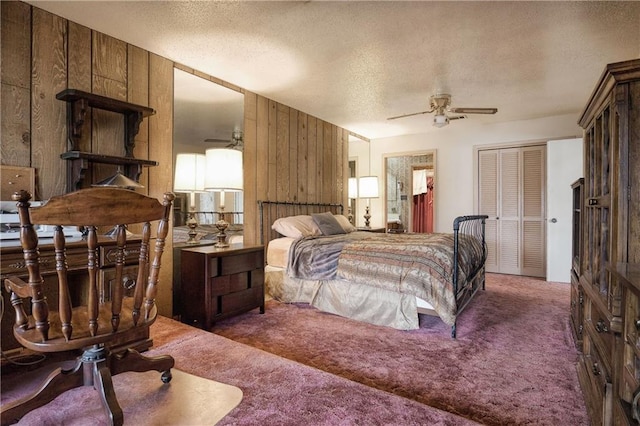 carpeted bedroom featuring wooden walls, a textured ceiling, and ceiling fan