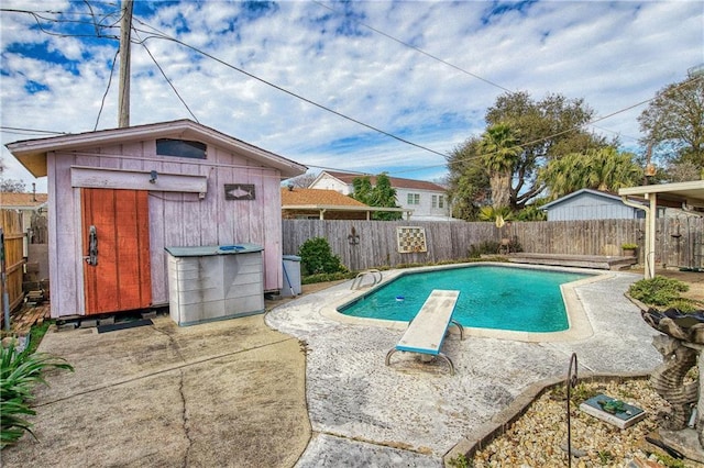 view of swimming pool with a diving board and a shed