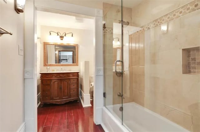 bathroom featuring vanity, wood-type flooring, and combined bath / shower with glass door