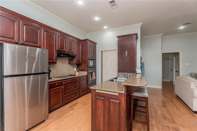 kitchen with decorative backsplash, sink, black appliances, and light hardwood / wood-style flooring