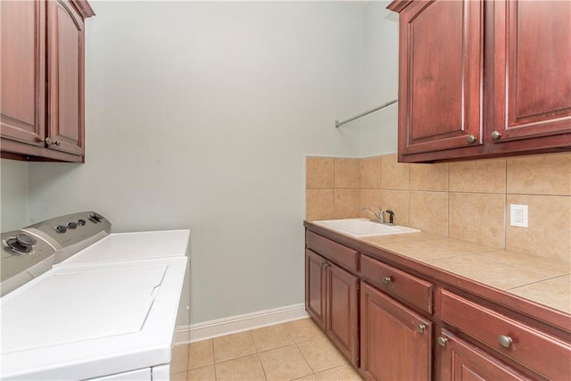 washroom with washer and dryer, cabinets, light tile patterned floors, and sink