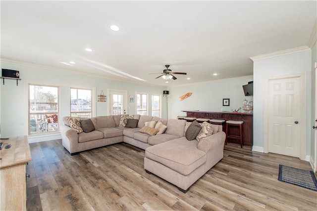 living room featuring light wood-type flooring, ceiling fan, and ornamental molding