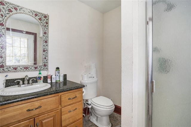 bathroom with toilet, an enclosed shower, and vanity