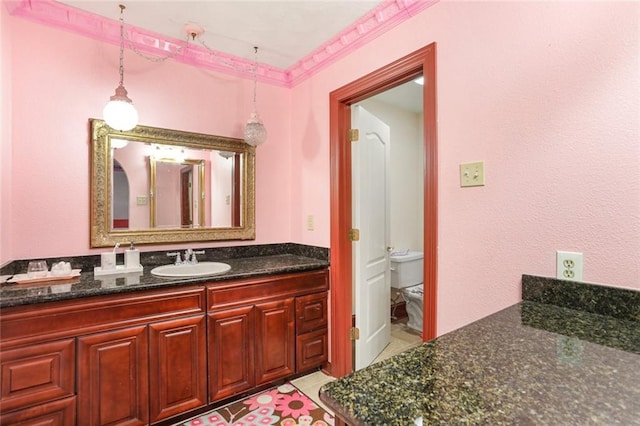 bathroom with toilet, vanity, tile patterned flooring, and crown molding