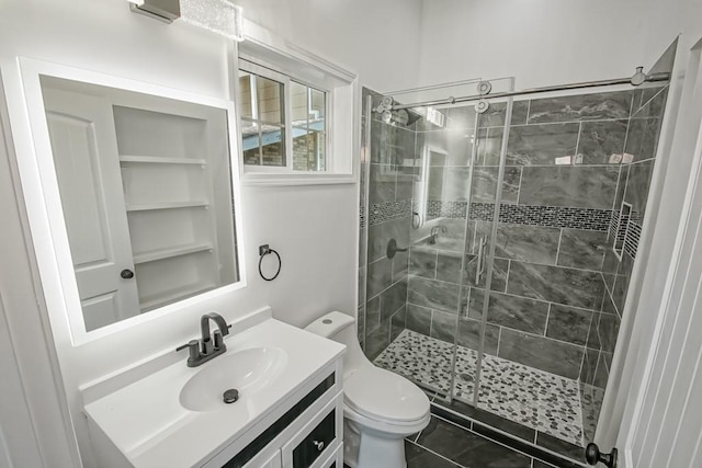 bathroom featuring tile patterned flooring, toilet, vanity, and a shower with shower door