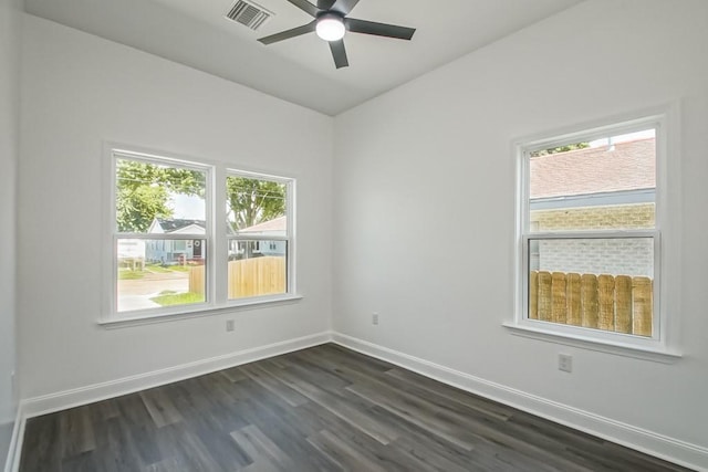 empty room with ceiling fan, plenty of natural light, and dark wood-type flooring