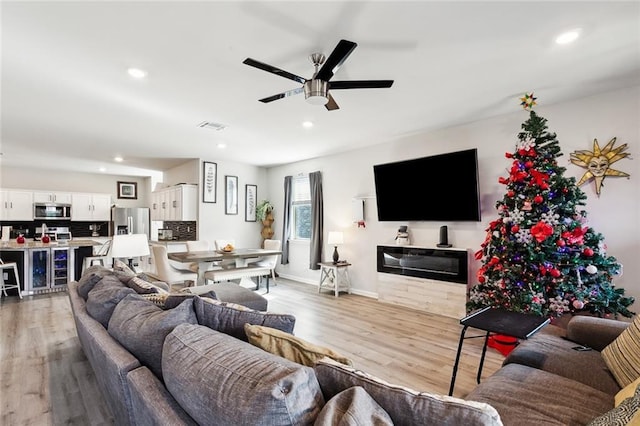 living room with ceiling fan and light hardwood / wood-style flooring