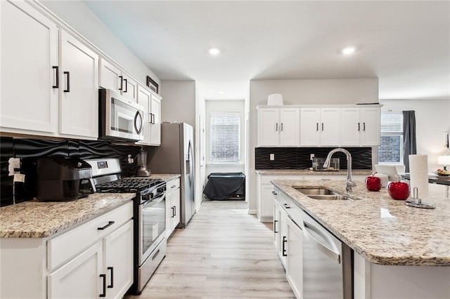 kitchen with appliances with stainless steel finishes, white cabinetry, and sink