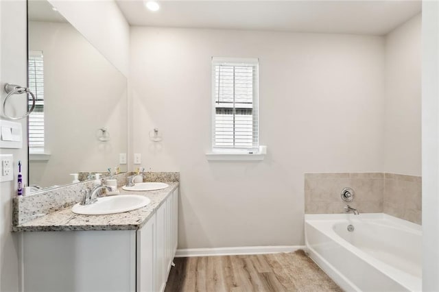 bathroom featuring a tub to relax in, vanity, and hardwood / wood-style floors