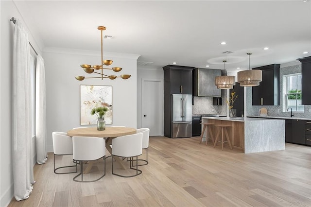 kitchen featuring pendant lighting, tasteful backsplash, sink, high end refrigerator, and a center island