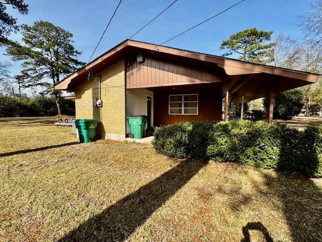 view of side of home with a yard