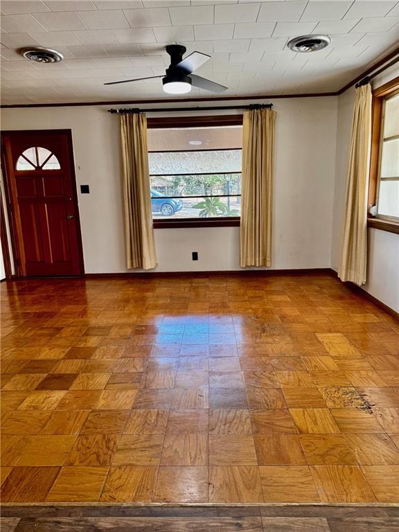 foyer with ceiling fan and parquet flooring