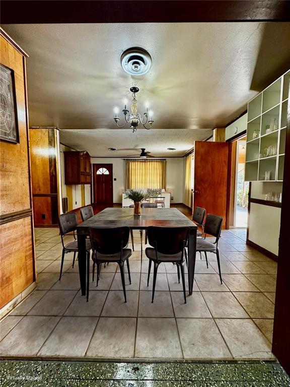 dining room featuring ceiling fan with notable chandelier