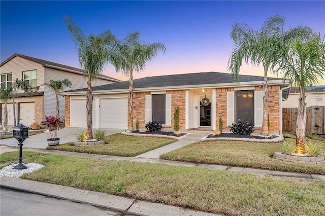 ranch-style home with a yard and a garage