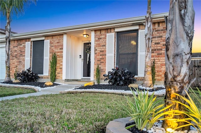 exterior entry at dusk with a yard