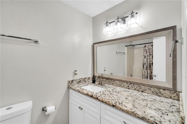 bathroom featuring toilet, a shower with shower curtain, and vanity