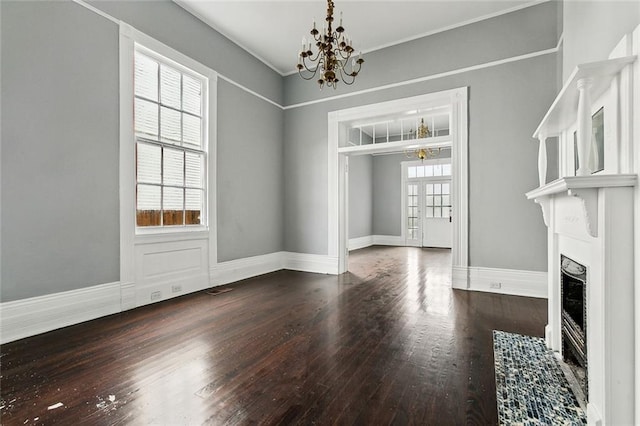 unfurnished dining area with dark hardwood / wood-style flooring, a chandelier, and plenty of natural light