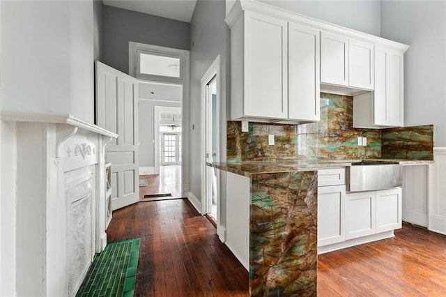 kitchen with dark hardwood / wood-style flooring, white cabinetry, and tasteful backsplash