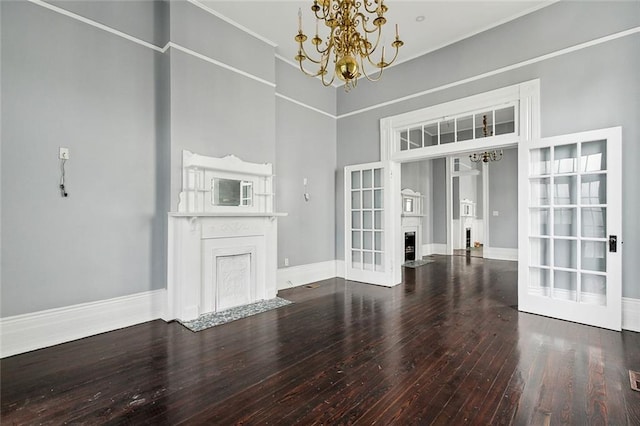 unfurnished living room with a notable chandelier, french doors, a high ceiling, and hardwood / wood-style flooring